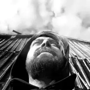 Portrait des Musikers von vorne und von unten, der Blick richtet sich über die Kamera